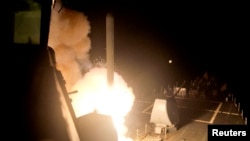 资料照片:美国海军“阿利·伯克号”导弹驱逐舰从红海向“伊斯兰国”目标发射一枚战斧式巡航导弹。(2014年9月23日)