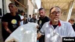 加沙地带南部的拉法,人们抬着一名在以色列空袭中丧生的世界中央厨房员工的遗体。(2024年4月3日)