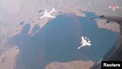 俄罗斯国防部2024年7月24日发布照片显示,中国空军一架 H-6K 轰炸机与一架俄军Su-30CM 喷气式战机在美国阿拉斯加州附近上空联合巡逻.