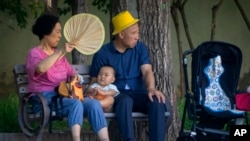 北京公园里一对老夫妇和一名幼儿在乘凉。(2023年6月29日)