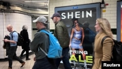 资料照片:英国伦敦市民走过地铁走道旁中国便宜服装品牌Shein的广告牌。(2024年3月8日)