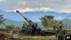 资料照片:一个少数民族武装团体的成员在缅甸掸邦辛威镇的一座山上检查据称从缅甸军队前哨基地缴获的武器。(2023年11月24日)