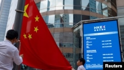 资料照:香港交易广场的一幅电子屏幕显示的香港恒生指数与一面中国国旗。(2023年8月18日)