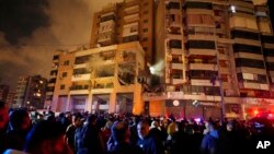 人群聚集在黎巴嫩南郊一座发生了爆炸的大楼外。哈马斯和真主党官员说,哈马斯高级官员阿鲁里被炸死。(2024年1月2日)