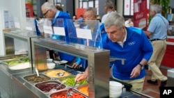 资料照片:国际奥委会主席托马斯·巴赫(Thomas Bach)在法国巴黎访问奥运村时品尝沙拉吧的食物。(2024年7月22日)