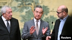 中国外交部长王毅与巴勒斯坦法塔赫领导人马哈茂德·阿鲁尔(左)和哈马斯高级成员穆萨·阿布·马祖克(右)在北京钓鱼台国宾馆交谈。(2024年7月23日)