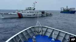 中国海警船和民兵船(图右上)在菲律宾近海的第二托马斯浅滩(仁爱礁)海域阻拦菲律宾海岸警卫队巡逻船。(2023年10月4日)