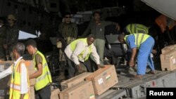 People move boxes after an Indian Air Force flight landed with medical aid, following the crisis in Sudan's capital Khartoum, at the military airport of Port Sudan, Sudan, May 18, 2023.