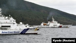 中国海警船进入有争议的尖阁列岛(中国称钓鱼岛)海域,在日本海岸警卫队巡逻舰旁驶过。(2024年4月27日)