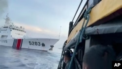 资料照片: 2023年10月22日编号为5203的中国海警船在南中国海碰撞菲律宾军用补给船后,菲律宾船员观望