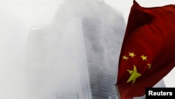 资料照:中国国旗在广州的一座高楼前飘扬。