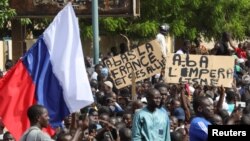 示威人士在尼日尔首都尼亚美举起一面俄罗斯旗帜进行反法和支持政变的游行。(2023年7月30日)