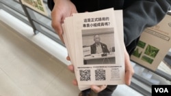 中大四年级学生徐同学2月25日在校友评议会周年大会场外派发传单,呼吁参与网上联署,反对有3名立法会议员提出的改组中大校董会议案 (美国之音/汤惠芸)