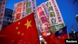 资料照 - 支持台湾独立和主张同中国大陆和平统一的台湾民众在台北举着各自的旗帜上街游行。(2016年5月14日)