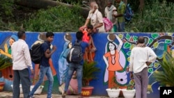 资料照片: 2023年8月24日印度民工在G20峰会宣传墙边