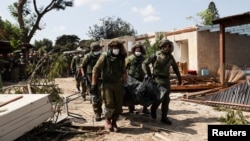 以色列士兵在以色列南部Kibbutz Kfar Aza地区抬着被巴勒斯坦武装分子杀害的以色列平民的遗体。(2023年10月10日)