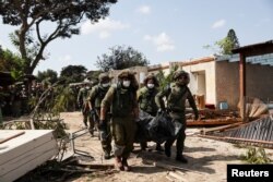 以色列士兵在以色列南部Kibbutz Kfar Aza地区抬着被巴勒斯坦武装分子杀害的以色列平民的遗体。(2023年10月10日)