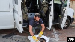 ဟာ့ဇ်လီယာမြို့တွင်းမှာ အစ္စရေးဗုံးရှင်းလင်းရေးတပ်ဖွဲ့ဝင် ရဲအရာရှိတယောက်က ပါလက်စတိုင်းစစ်သွေးကြွတွေပစ်လွှတ်တဲ့ မစ်ဇိုင်းဒုံးအပိုင်းအစတွေကို လိုက်လံကောက်ယူရှင်းလင်းနေစဥ်။ (မေ ၂၆၊ ၂၀၂၄)