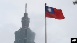 资料照片:台湾的青天白日满地红旗帜在台北101大楼旁飘扬。(2023年5月7日)