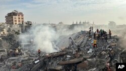 2023年10月31日,以色列空袭加沙地带努塞拉特难民营后,巴勒斯坦人寻找幸存者。(美联社照片)