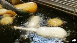 资料照片：2007年8月8日，在美国印第安纳波利斯市举办的印第安纳州博览会的食品摊位上，正在使用不含反式脂肪的油煎炸糖果。（美联社照片）