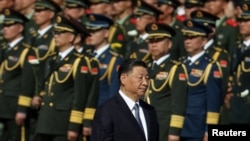 中国领导人习近平在国庆日之前向天安门广场人民纪念碑鲜花时走过中国军人的队伍。(2023年9月30日)