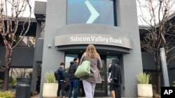 People stand outside of an entrance to Silicon Valley Bank in Santa Clara, California, March 10, 2023.