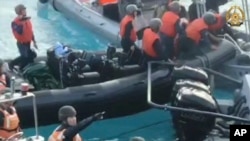 在菲律宾武装部队提供的这张图片中,中国海警手持刀具和砍刀,向在有争议的南中国海第二托马斯浅滩(中国称仁爱礁)执行补给任务的菲律宾军队靠近。(2024年6月17日)