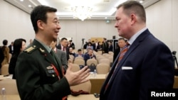 资料照片: 美国前助理国防部长施灿德在北京出席香山论坛期间与中国国防部发言人吴谦交谈(2023年10月30日)