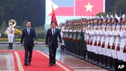 资料照:菲律宾总统马科斯(右)与时任越南国家主席武文上在河内举行的欢迎仪式上检阅越南仪仗队。(2024年1月30日)