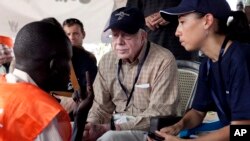 Cựu TT Carter nói chuyện với nhân viên bầu cử tại một phòng phiếu ở Nam Sudan, 2010.