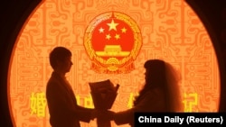 中国浙江省杭州市婚姻登记处的一对新人在情人节登记结婚。(2023年2月14日)