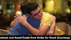 穿着黄色印有“国家地理杂志”字样的T恤的吉尔·哈祖特(Gil Hazut),哈马斯袭击的幸存者,忍不住在古特曼的拥抱中失声痛哭。(照片受访者提供)