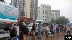 北京门头沟区遭洪水袭击供水系统被破坏后,居民排队领取清洁水。(2023年8月1日)