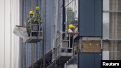 资料照:中国工人在北京的一处住宅楼工地施工。(2023年7月29日)