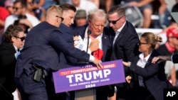 在宾夕法尼亚州巴特勒市举行的一场竞选活动上,美国共和党总统候选人、前总统唐纳德·特朗普(Donald Trump)被搀扶下台。(2024年7月13日)