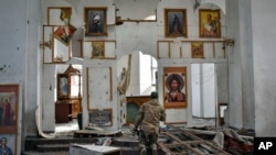 A Ukrainian serviceman prays kneeling in a church damaged in the Russian air raid in the town of Orikhiv, Zaporizhzhia region, Ukraine, April 5, 2024.