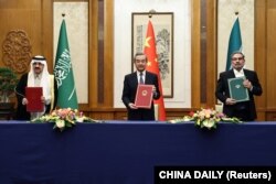 中共中央外办主任王毅与伊朗最高国家安全委员会秘书阿里·沙姆哈尼(右)同沙特国务大臣、内阁成员和国家安全顾问穆萨伊德·本·穆罕默德·艾班在北京举行会谈。(2023年3月10日)