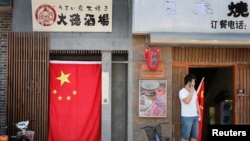资料照:北京靠近日本驻华大使馆附近的一家日本餐馆大门挂着一面中国国旗。(2012年9月14日)