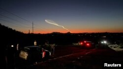 资料照片:人们在毗邻加利福尼亚州的亚利桑那州的一处山丘观看太空探索公司的“猎鹰9号”火箭从范登堡太空军基地发射升空。(2024年4月6日)