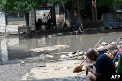 河北涿州居民清理遭洪水破坏的家园。(2023年8月9日)