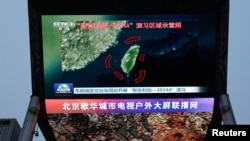 资料照片:北京街头巨幅电视屏幕播放中国军队东部战区绕台军演的新闻。 (2024年5月23日)