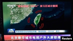 北京街头巨幅电视屏幕播放中国军队东部战区绕台军演的新闻。 (2024年5月23日)