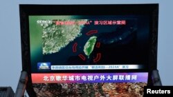 资料照片:北京街头巨幅电视屏幕播放中国军队东部战区绕台军演的新闻。(2024年5月23日)