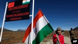 资料照:一个印度女孩手举印度国旗站在印度阿鲁纳恰尔邦的中印边界线上。(2012年10月21日)