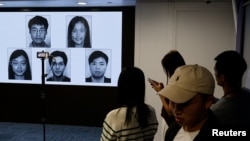 香港当局在记者会上公布被通缉的五名活动人士的照片。(2023年12月14日)
