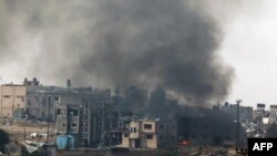 2023年12月27日,在以色列南部与加沙地带接壤的地方拍摄的一张照片显示,以色列轰炸巴勒斯坦领土后冒出的浓烟。(法新社照片)