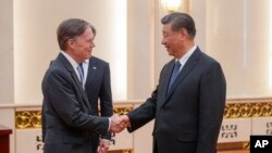2024年4月26日,美国驻华大使伯恩斯与中国领导人习近平在北京人民大会堂握手。(美联社)