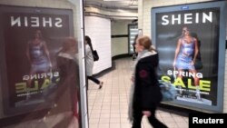 资料照:英国伦敦一名女子走过地铁走道旁中国便宜服装快时尚品牌Shein的广告牌。(2024年3月8日)