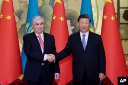 资料照片: 2023年5月17日哈萨克斯坦总统托卡耶夫(左)与中国国家主席习近平在西安中国-中亚峰会上握手